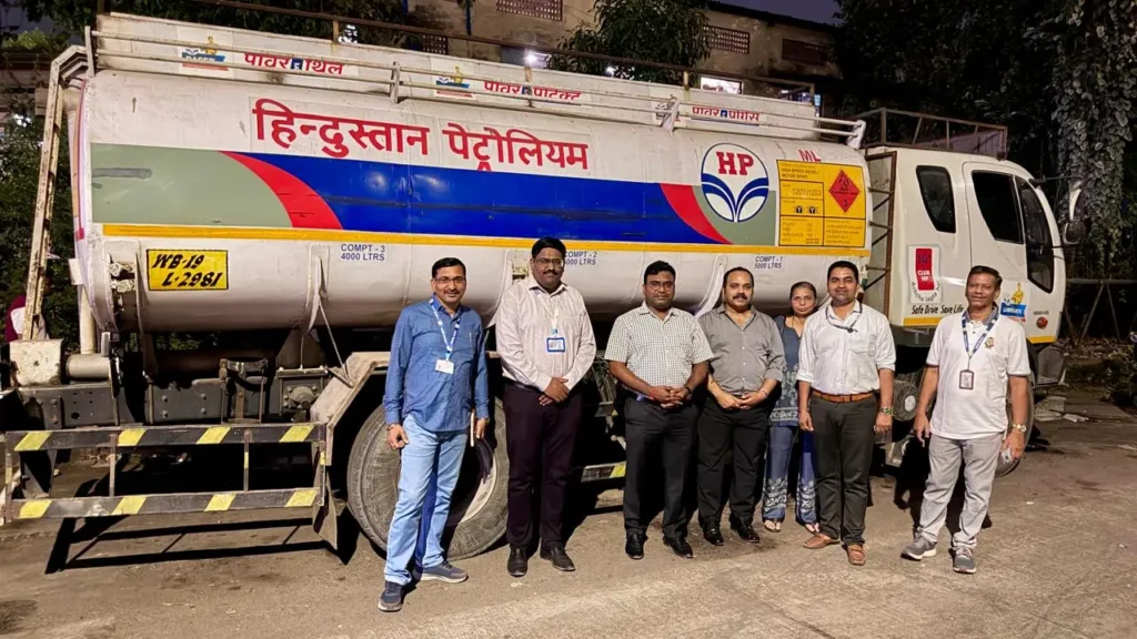 तुर्भे में जब्त टैंकर के सामने मुंबई-ठाणे राशन वितरण विभाग की कार्रवाई में शामिल अधिकारी